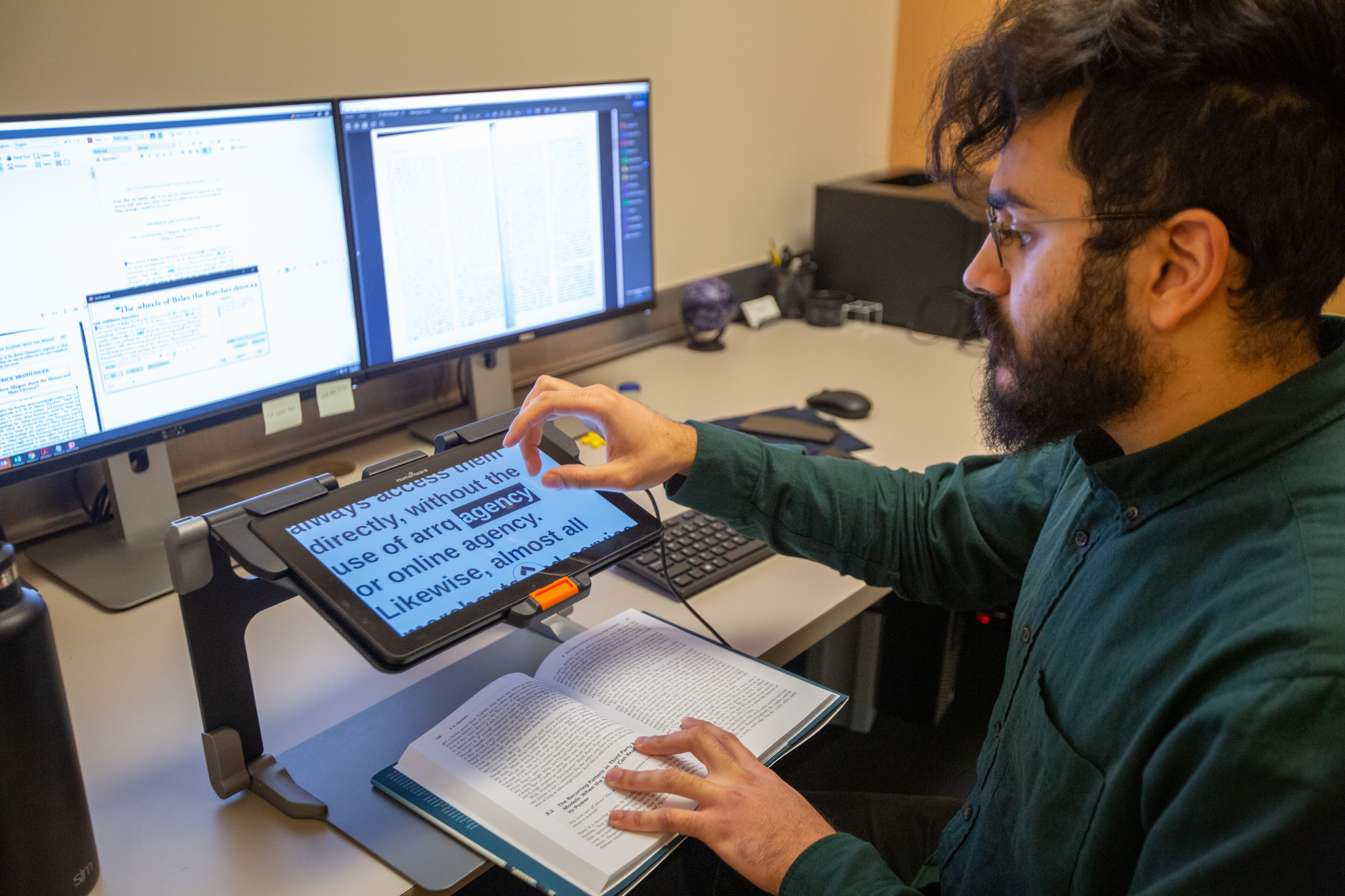 Person reading a textbook using magnifying technology
