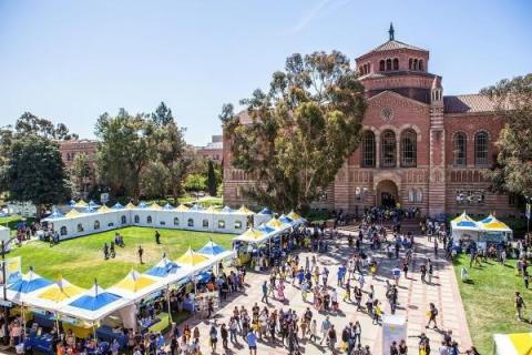 Looking down at UCLA's Royce Quad while an event takes place with tables and lots of people.